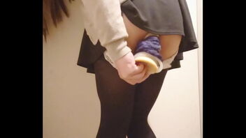 A solo performance of a Japanese girl masturbating with a dildo in a public setting.