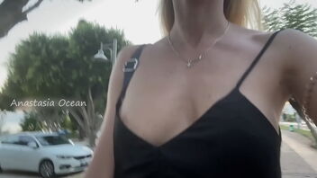 A beautiful woman wears a short dress and no panty, exposes her breasts in public.