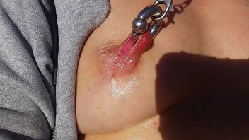 Scorching milf masturbates outdoors with vibrator and has pierced nipples.